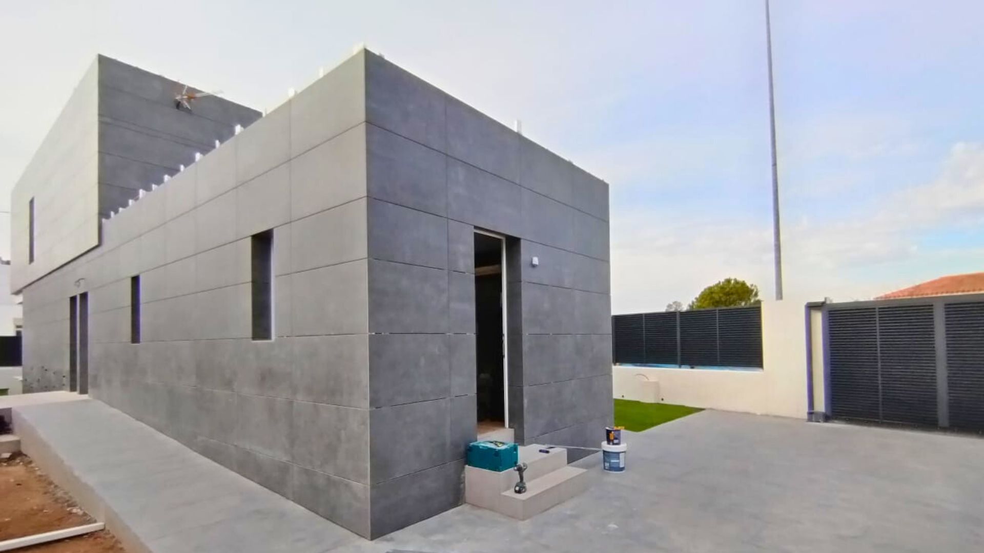 Vivienda industrializada, con fachada ventilada de piedra natural de color gris